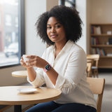 A woman wearing a Bakers Bands Limited bright guava nylon sport loop on her Apple Watch while holding a coffee cup.