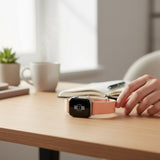 Bakers Bands Limited cantaloupe nylon woven sport loop band for Apple Watch on a wooden desk with a notebook and mug.